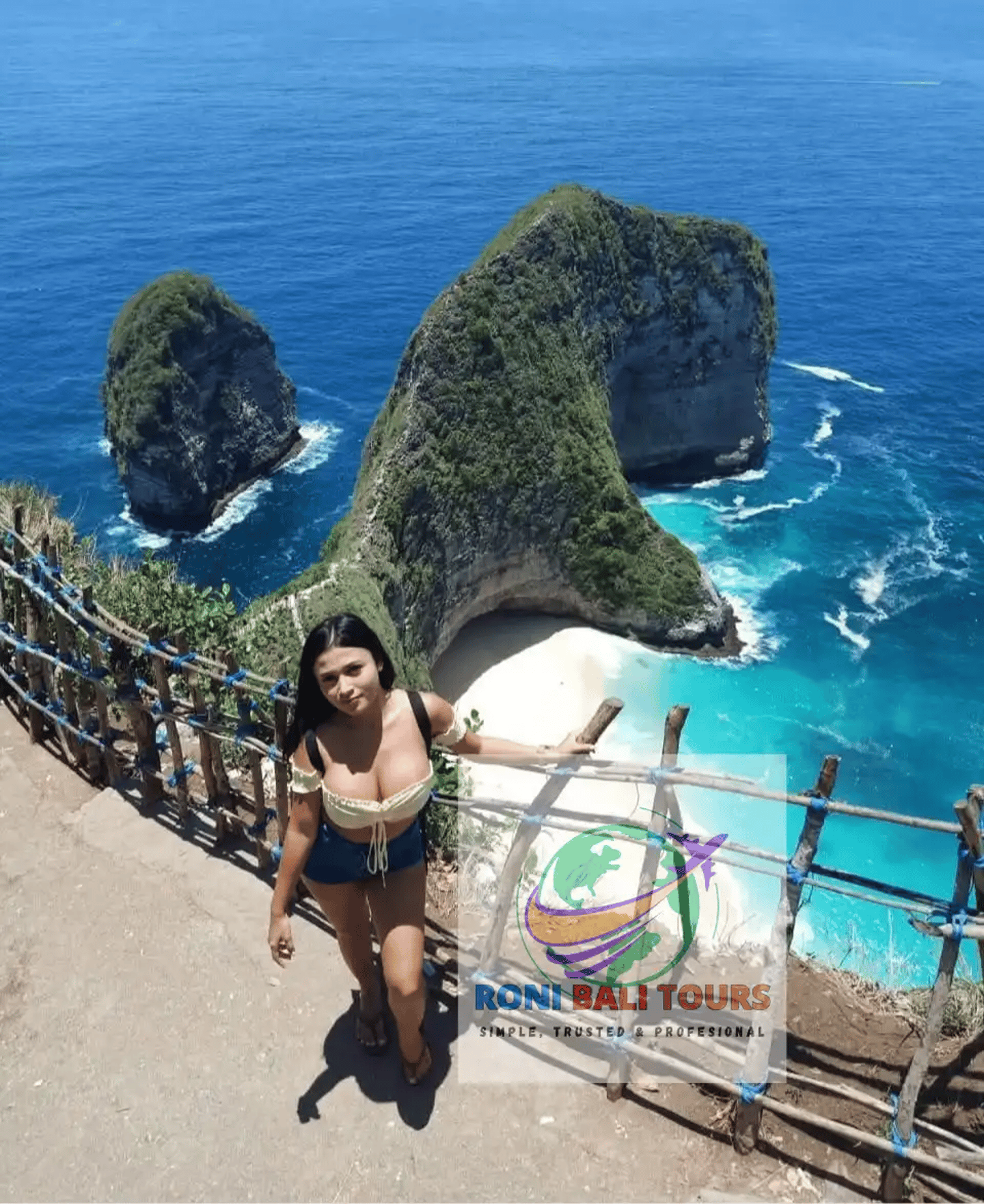 Woman posing at Kelingking Beach viewpoint overlooking the iconic T-Rex bay in Nusa Penida, Bali.