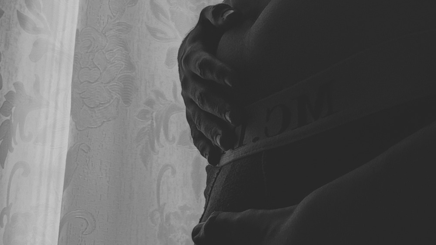 Primer plano artístico en blanco y negro de manos sobre el abdomen.