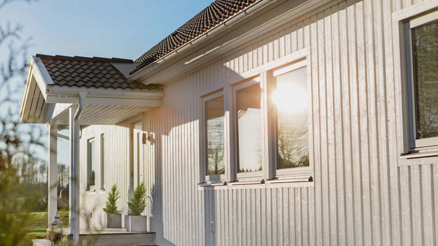 Une façade de maison avec un bardage en bois peinte avec de la peinture suedoise blanche 