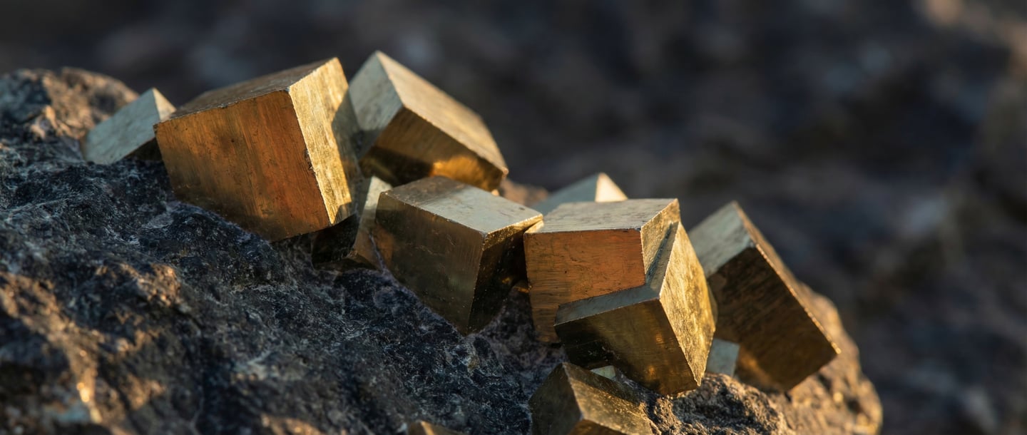 Gros plan de Cubes dorés de Pyrite naturelle sur roche