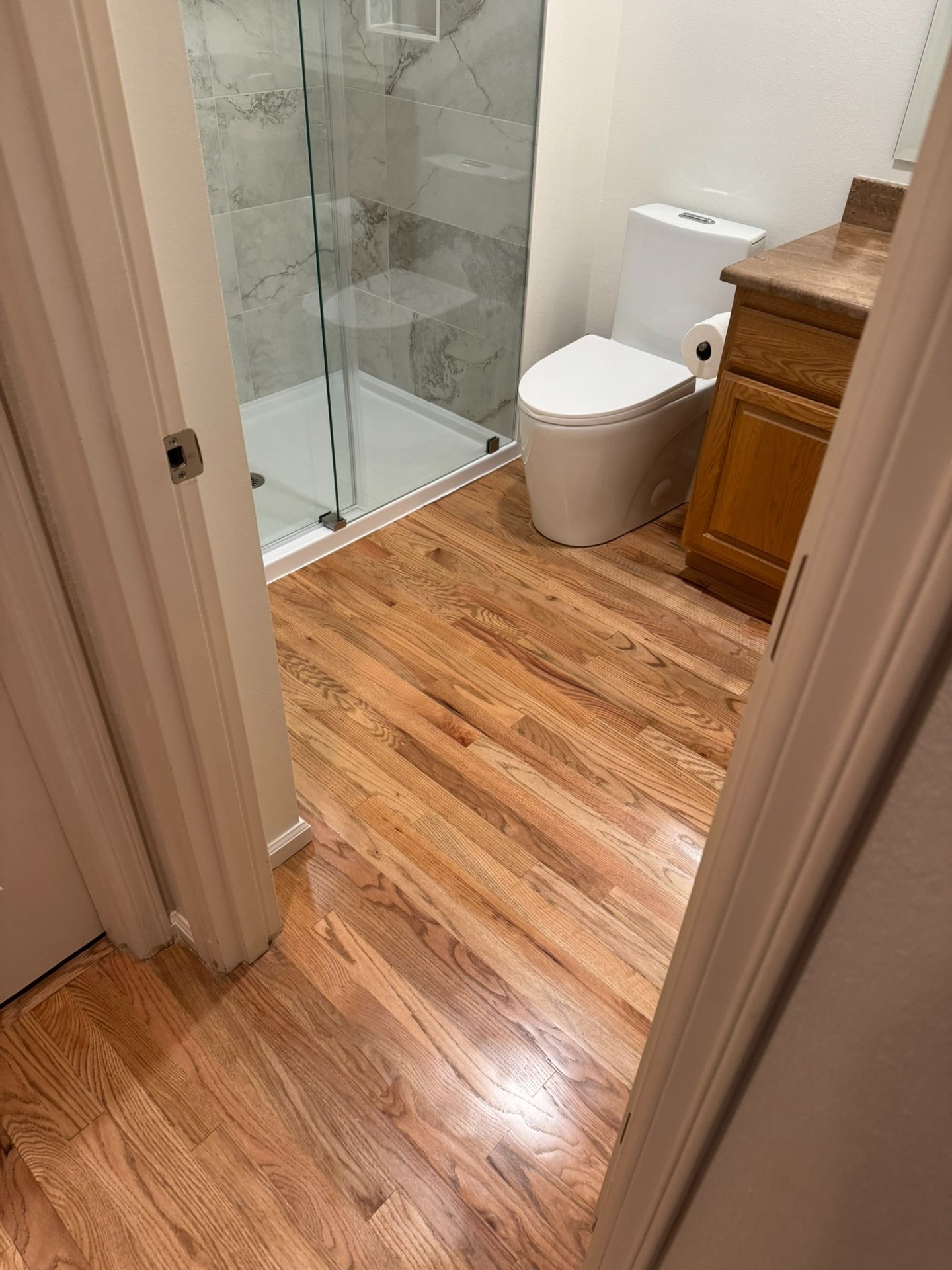 Bathroom Remodel with new plumbing fixtures, skirted modern toilet, large format porcelain tiles.