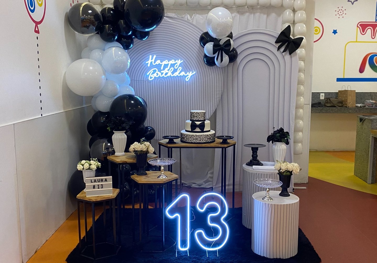 Aluguel de decoração teen preta e branca na Freguesia do Ó com painel ripado e laços decorativos