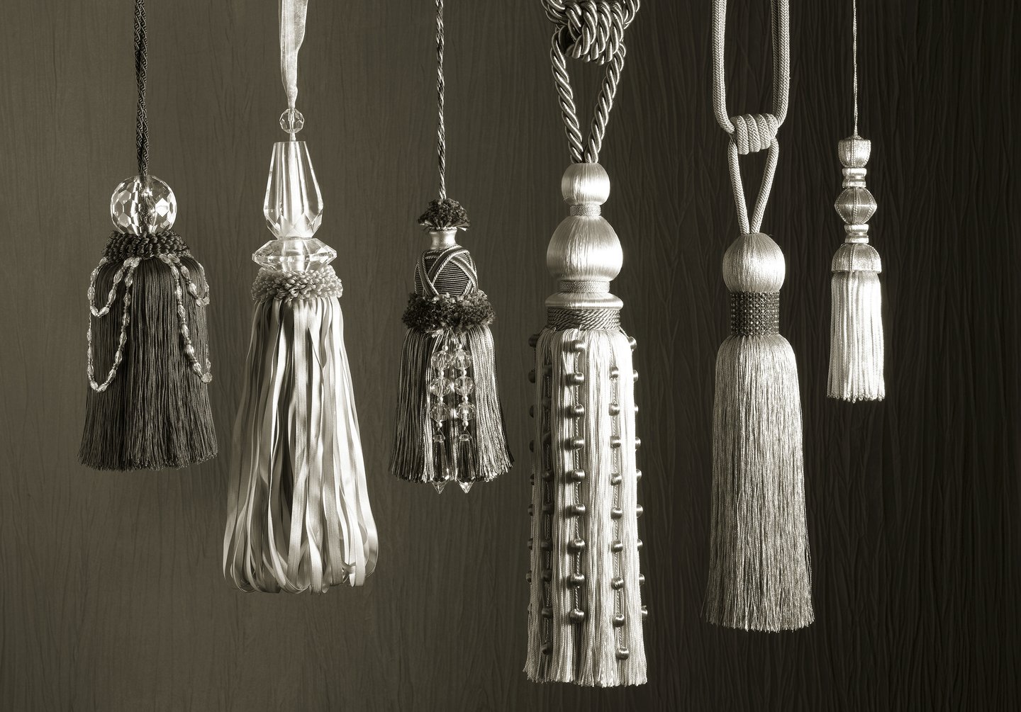 black and white image of ornate tassles against a textured fabric background