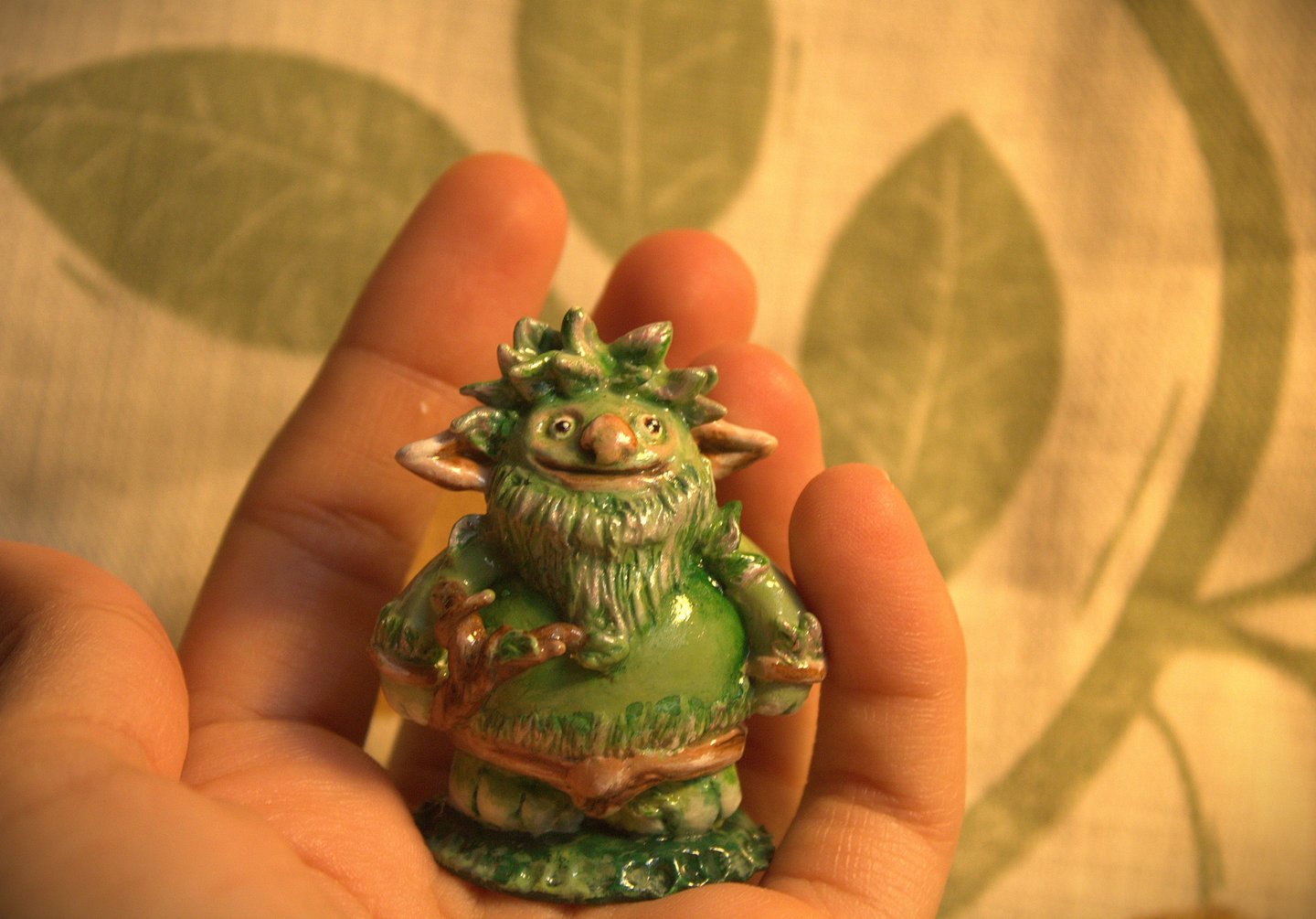small green troll with leaves sculpted figurine