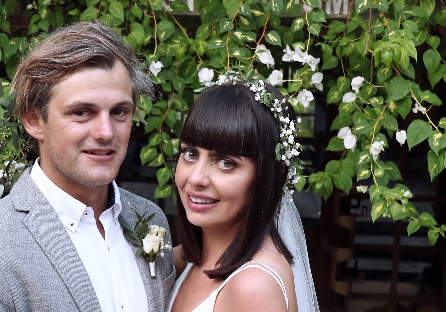 a bride with a floral head piece and groom posing at their wedding is Bali