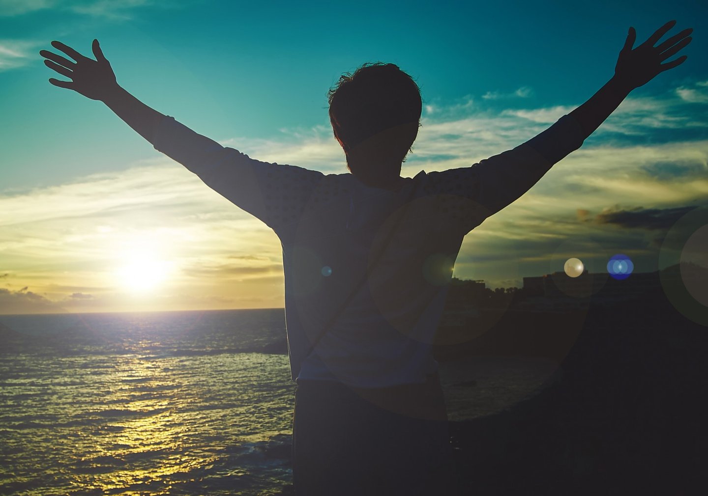 homme levant les bras face au soleil. nouveau depart grace a la therapie breve