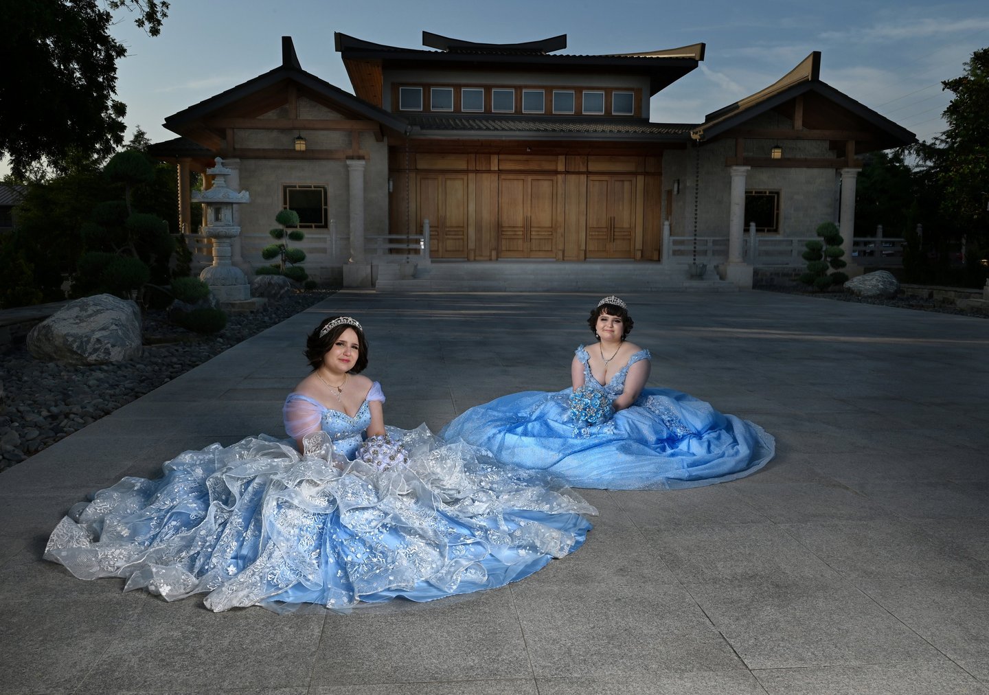 two women in quince dresses sitting on the ground