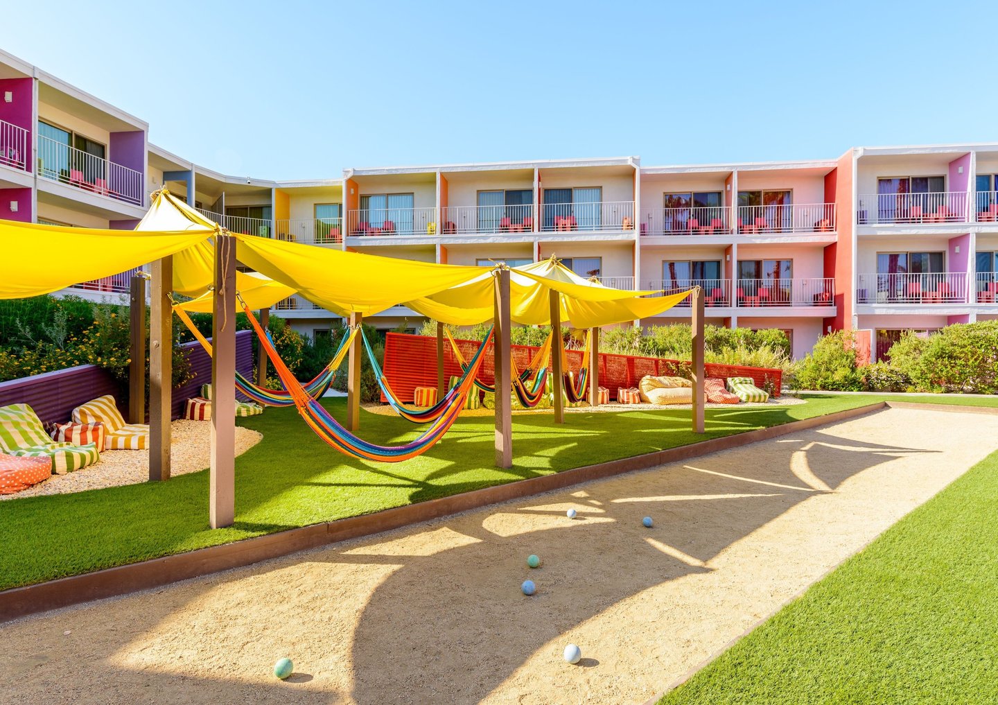 The Saguaro Palm Springs hotel with colorful rooms, shaded hammocks, and outdoor courtyard