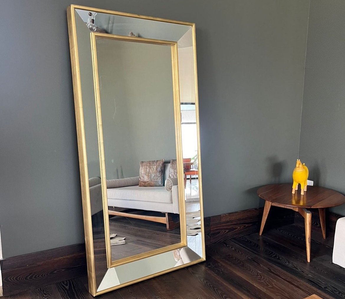 a mirror mirror in a room with a couch and a table