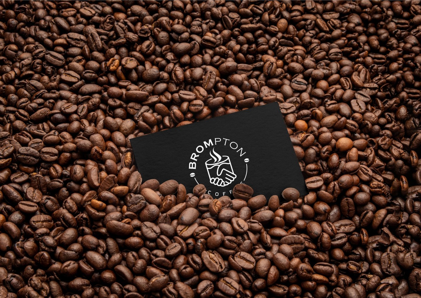 a business card with a coffee cup on top of a pile of coffee beans