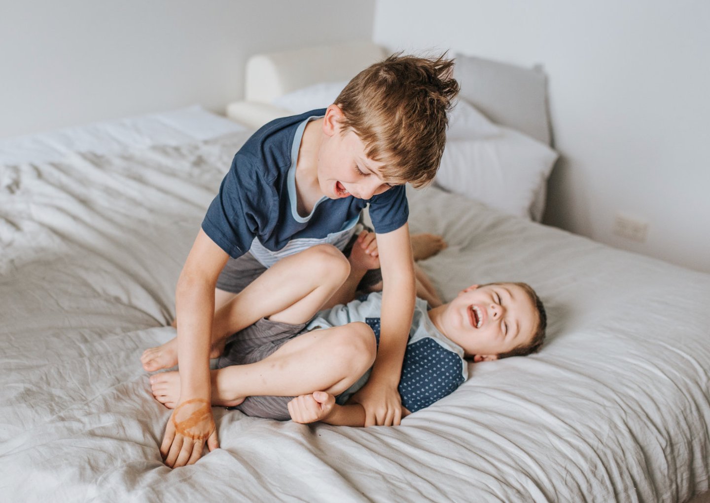 Two children play wrestling and smiling