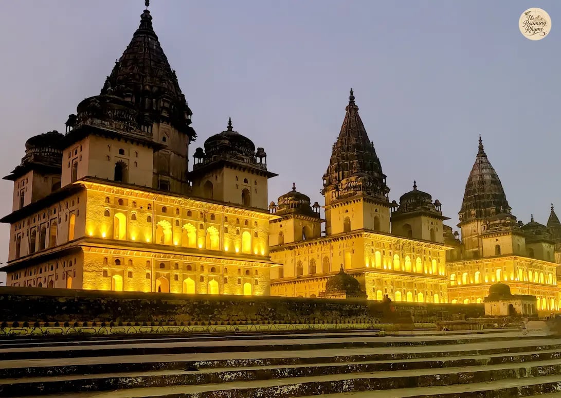 Orchha's royal cenotaphs illuminated at night.