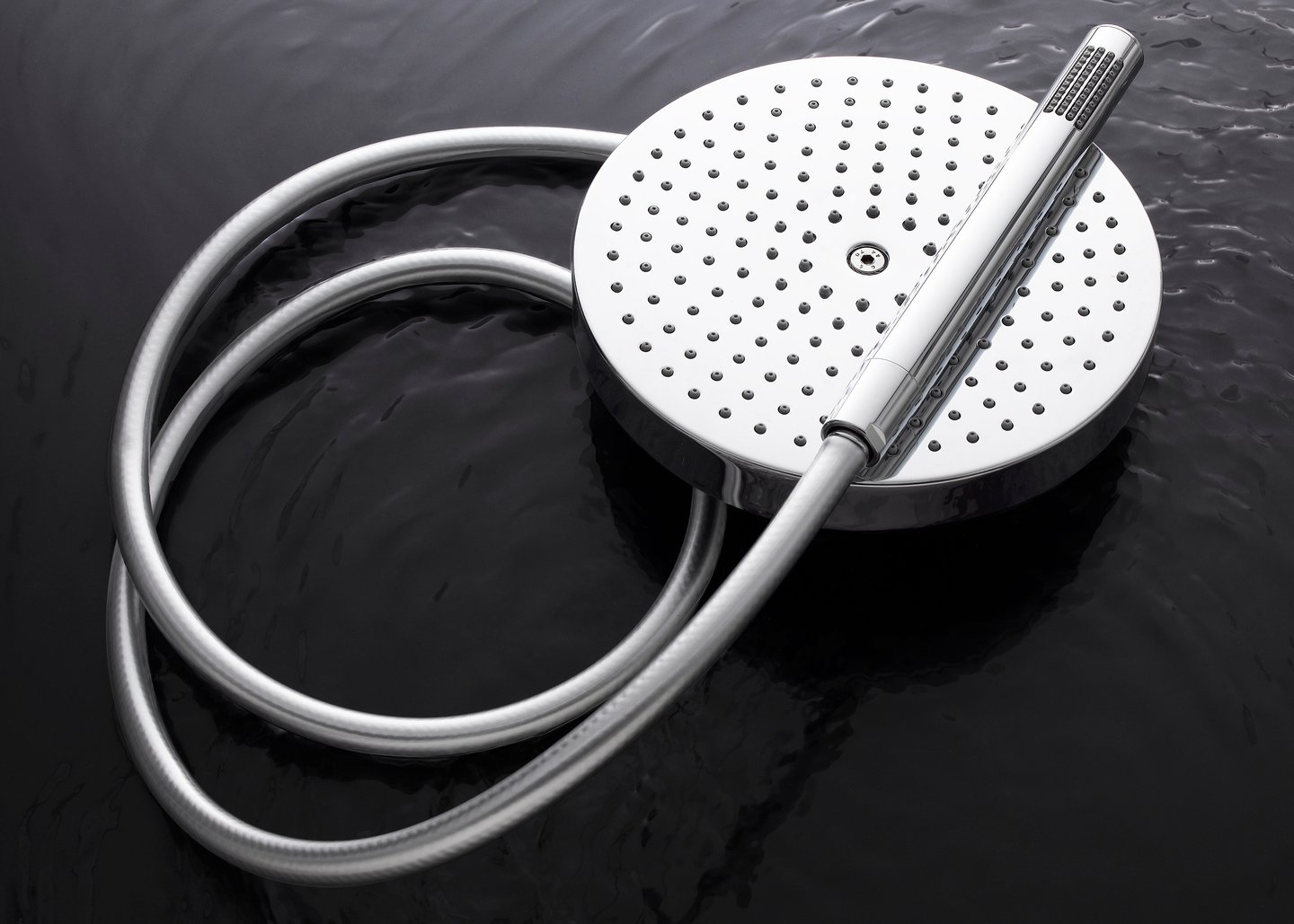 chrome rain shower head and wand floating on water
