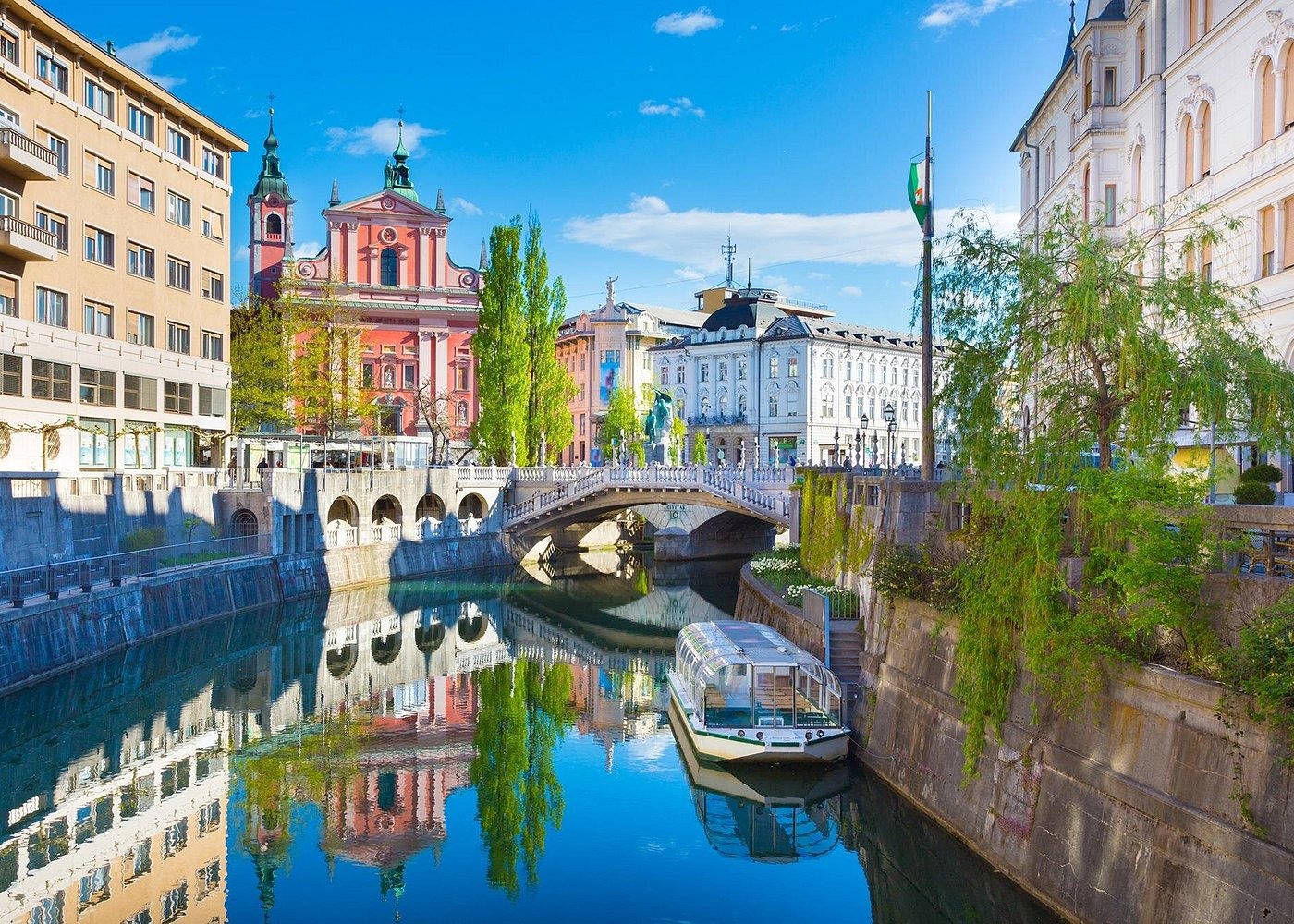Ljubljanica River in Ljubljana, Slovenia, featuring the Triple Bridge and the pink Franciscan Church.