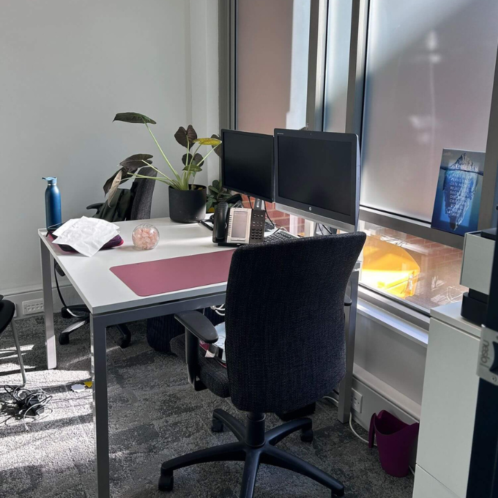 a desk with a computer monitor and a desk with a chair