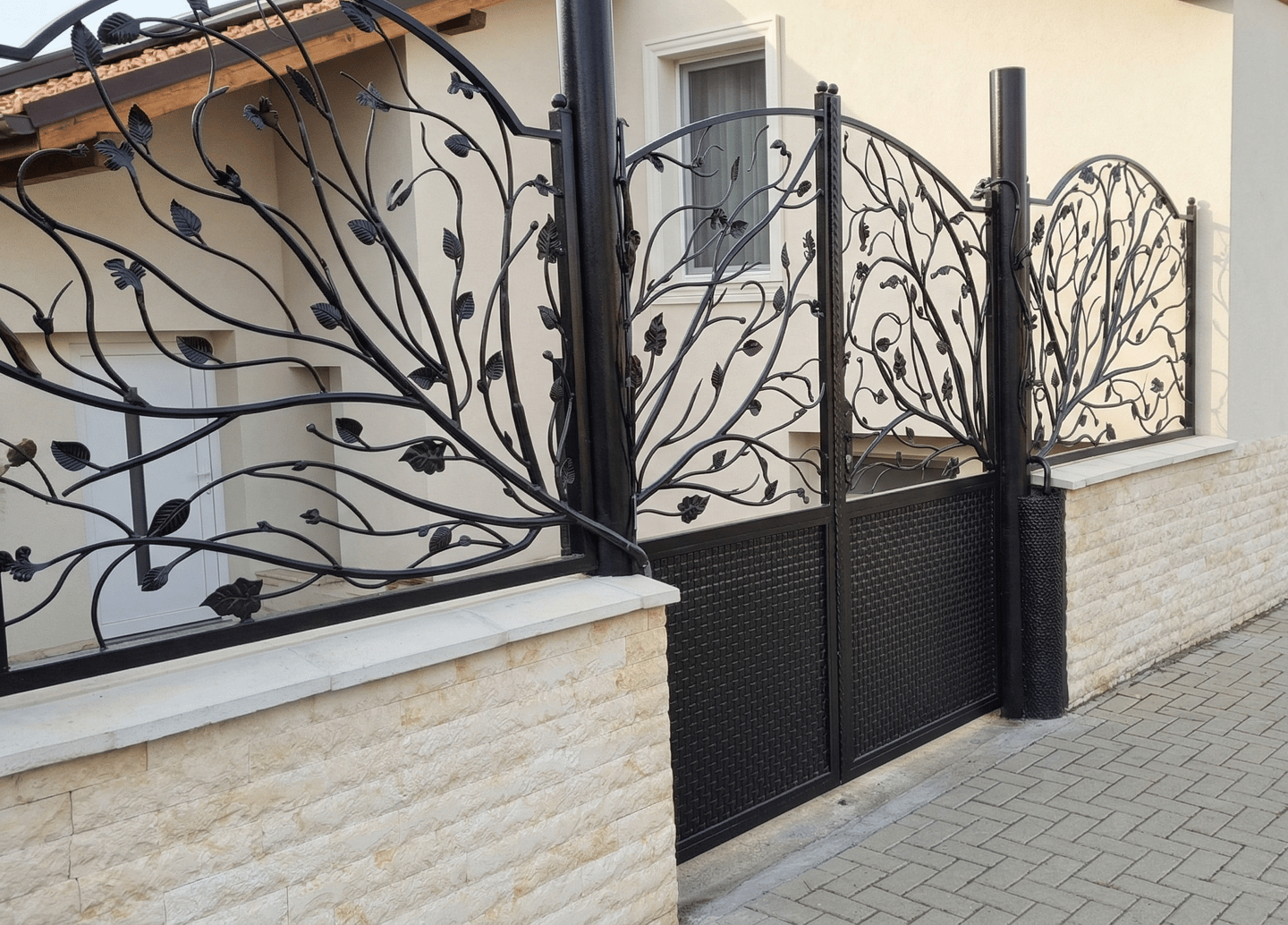 Custom decorative wrought iron gate and matching fence with a black leaf and vine design.