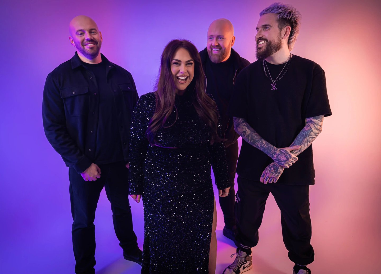 a group of people standing around a woman in a black dress