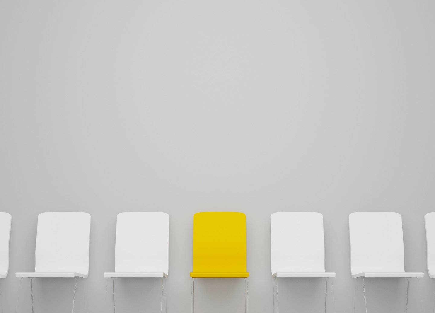 Yellow chair standing out from row of white chairs