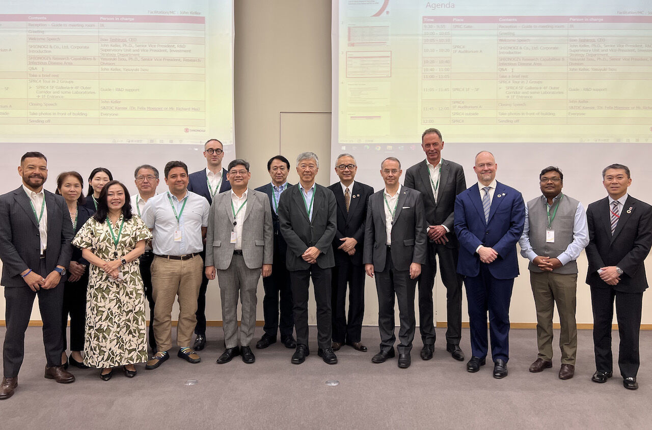 Members of S&TDC Kansai standing in front of a presentation