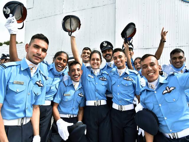 Air Force cadets in uniform, throwing their caps in the air, celebrating their graduation with joy and pride