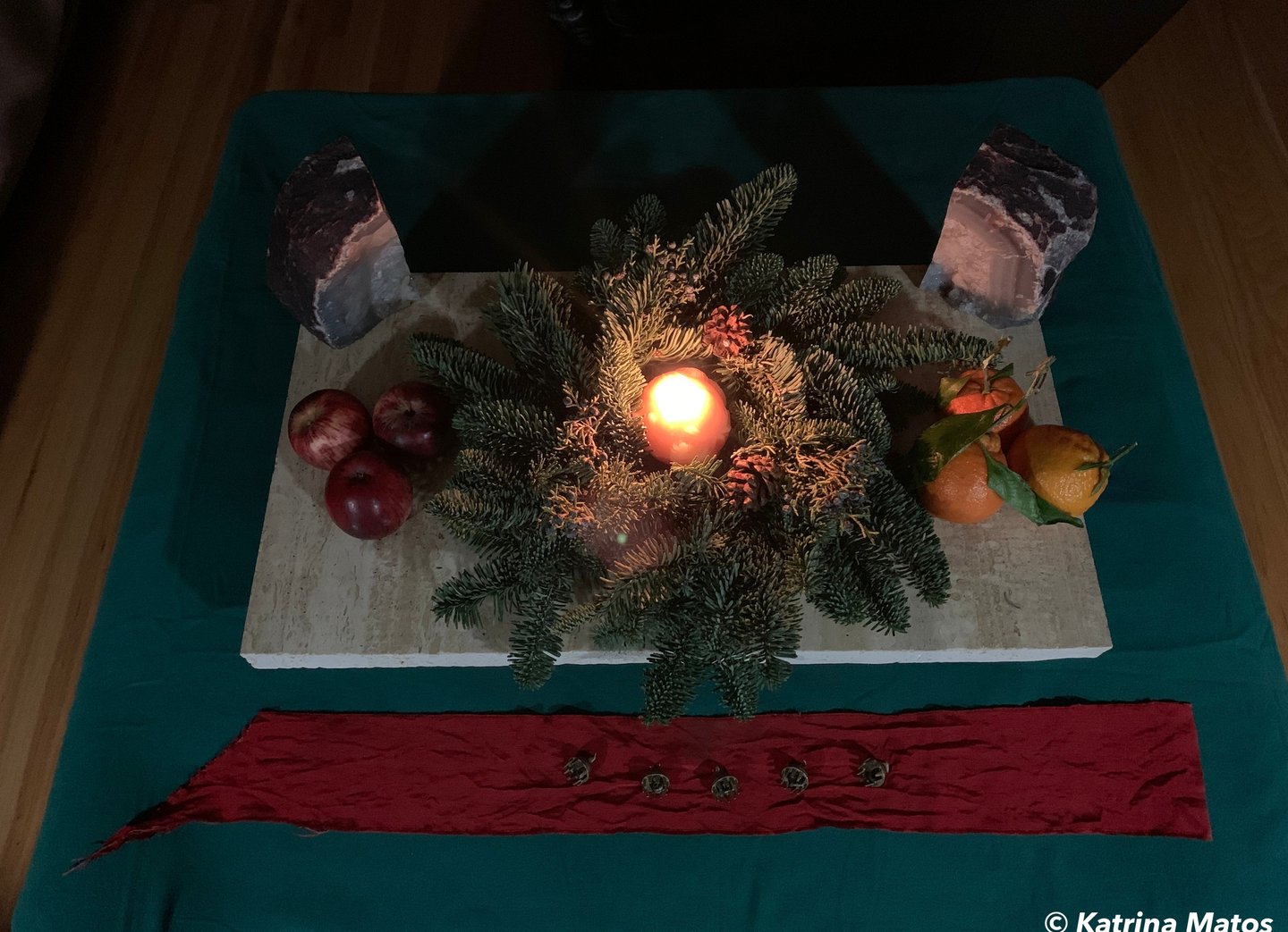 evergreen wreath on marble altar with lighted candle in the center