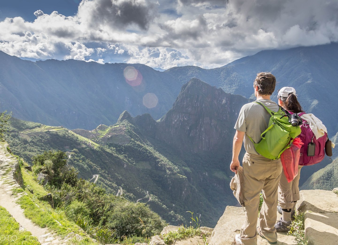 This image captures trekkers on the Inca Trail to Machu Picchu, Peru, admiring the breathtaking Andean landscape.