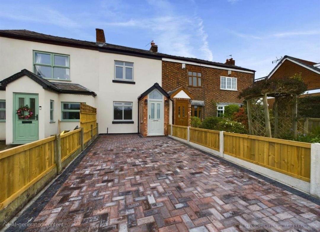 Modern kitchen and dining room with a large island, sleek white table, orange pendant lights, skylight, and black-framed