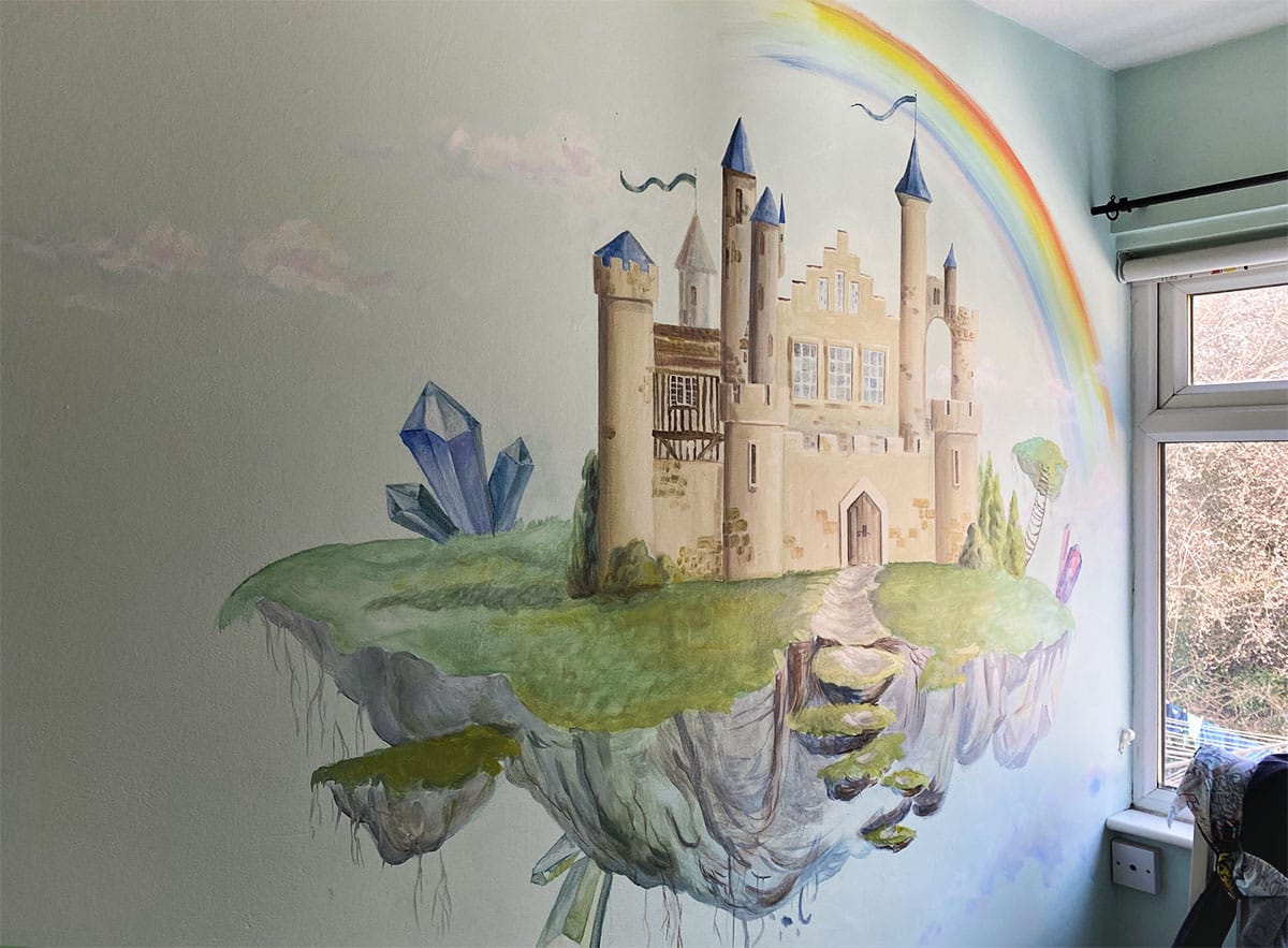 Kid's mural of a magical castle with crystals, a rainbow and white clouds