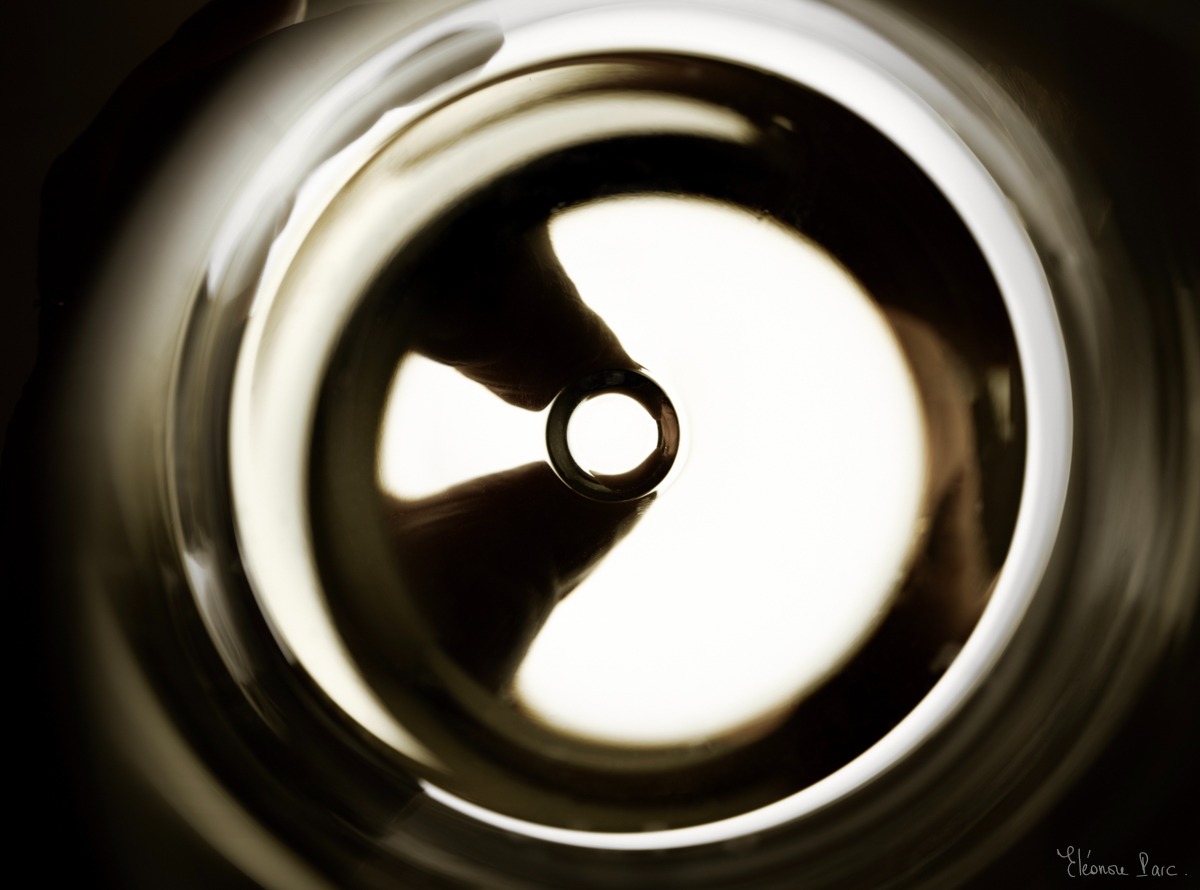 deux doigts qui tiennent le verre de vin, vue de dedssus très graphique.