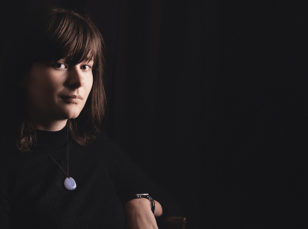 a woman in a black shirt and a necklace with a blue necklace