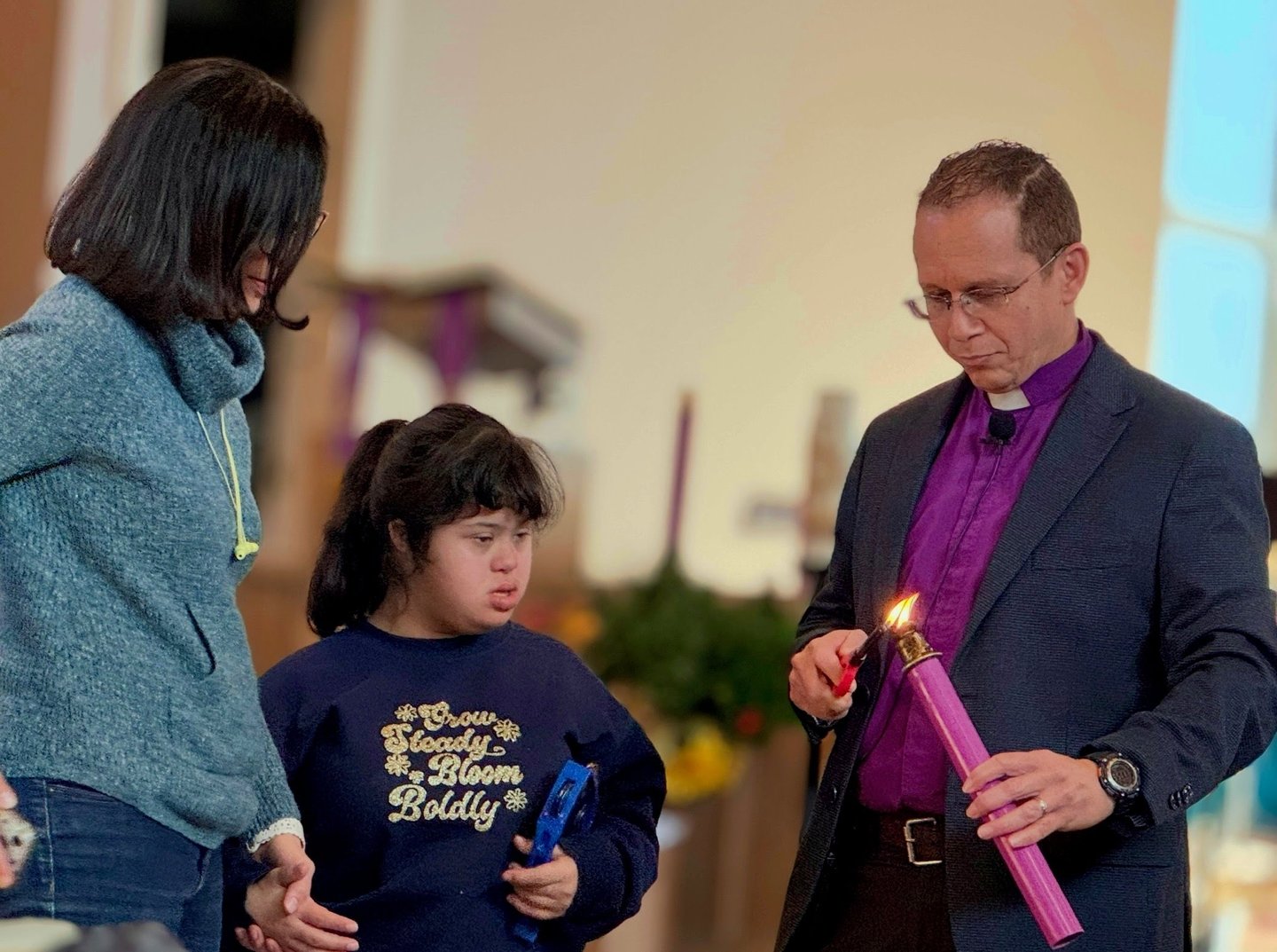 a priest holding a candle in a church