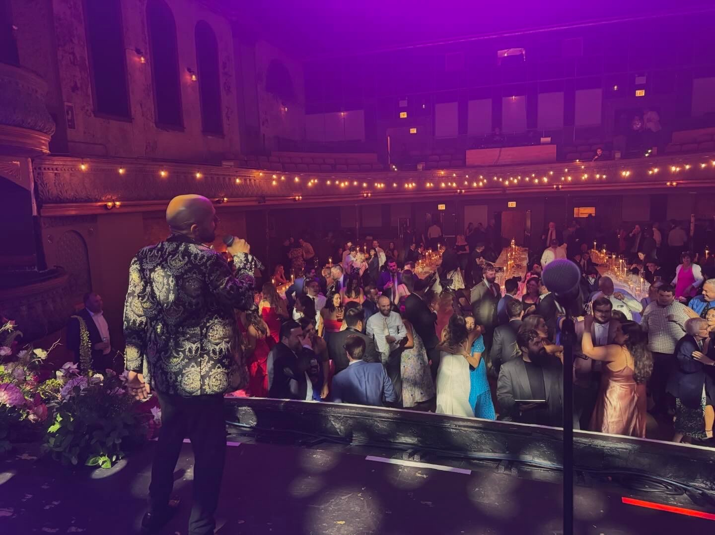 LuxeBand singer performing on stage at a historic venue