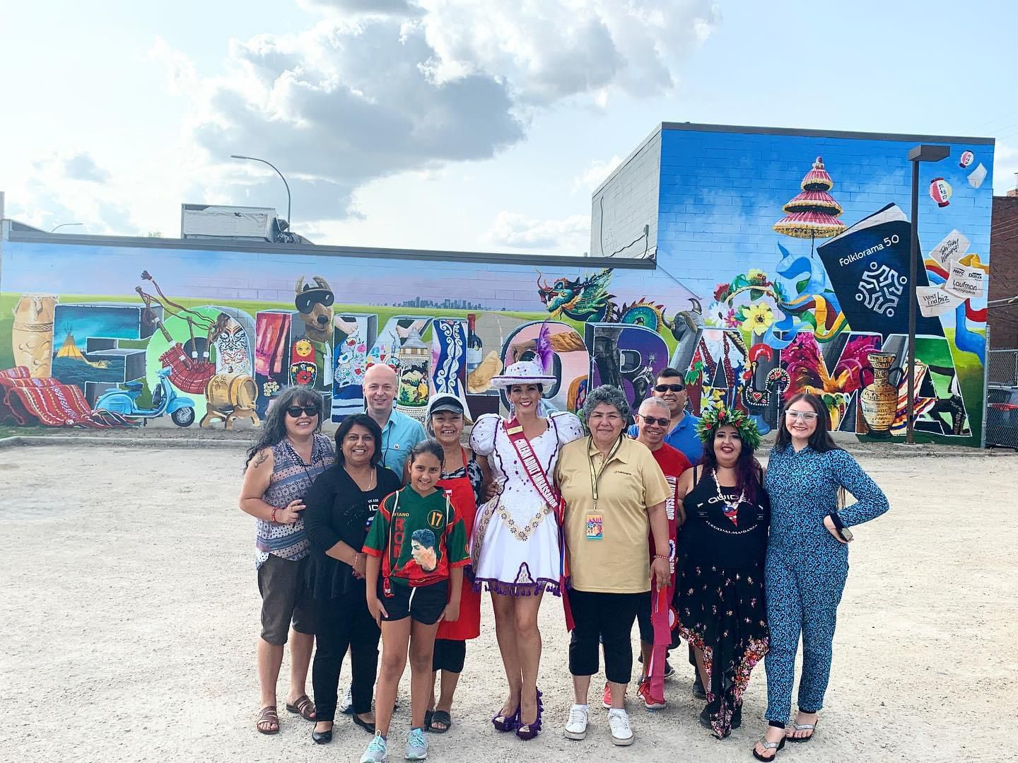 a group of people standing in front of a mural