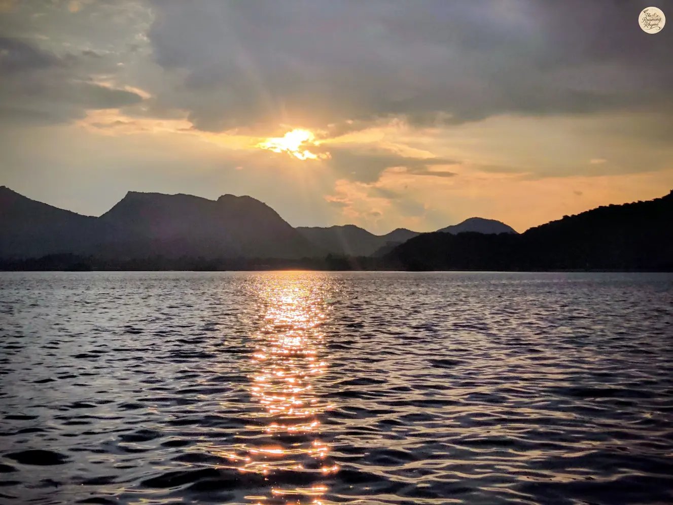 Warm golden reflections shimmering across Fateh Sagar udaipur during sunset.