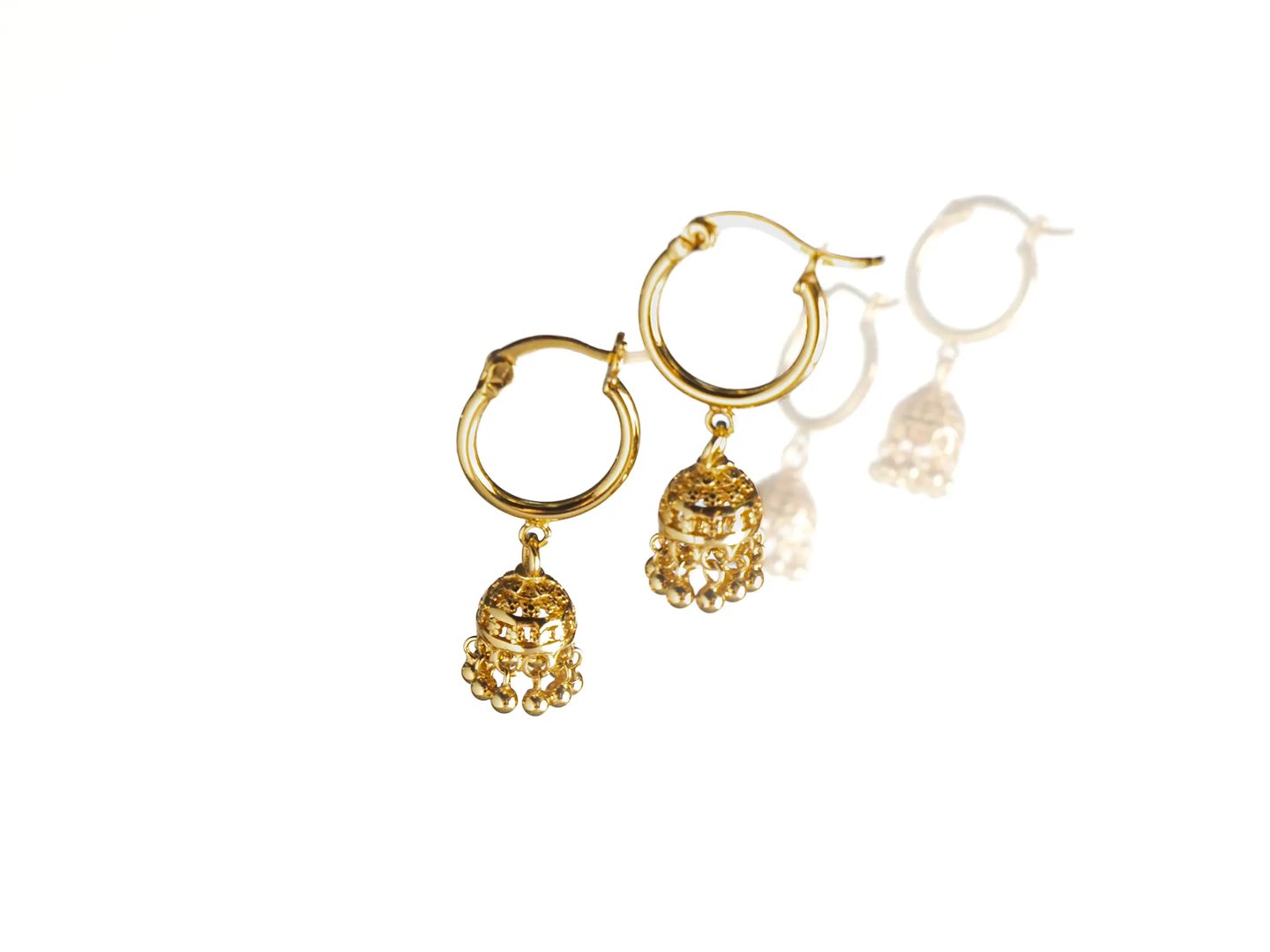 Gold jhumka hoop earrings photographed on a clean white background
