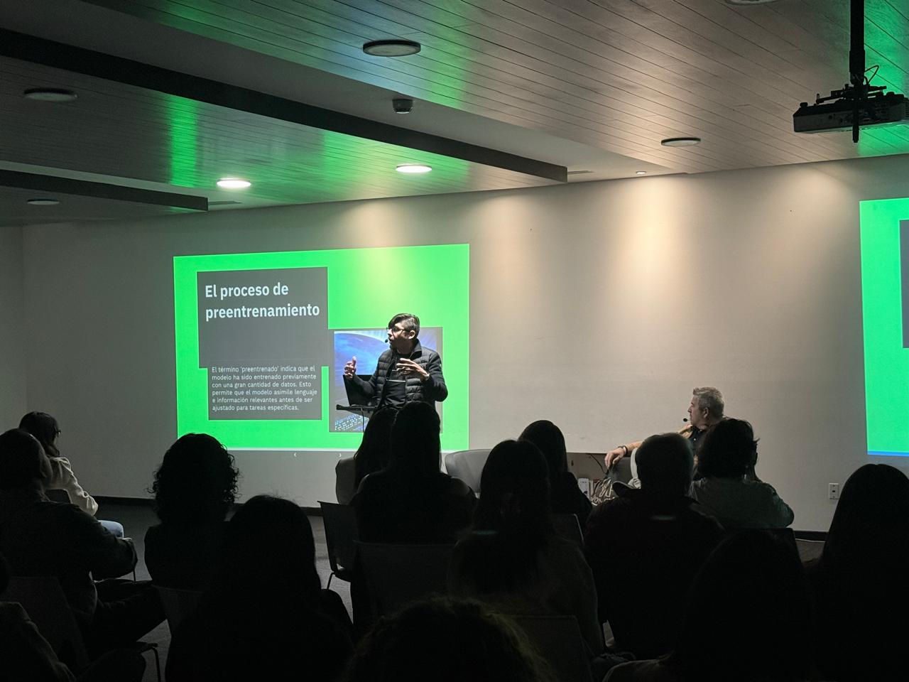 Speaker presenting an AI pre-training process seminar to an audience in a modern conference room.