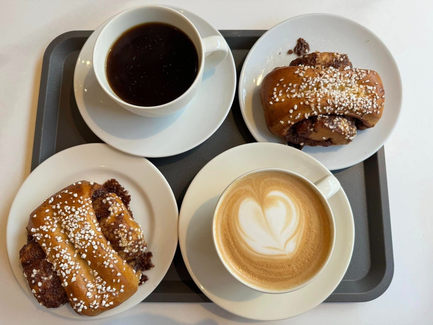 a tray with two cups of coffee and two pastries