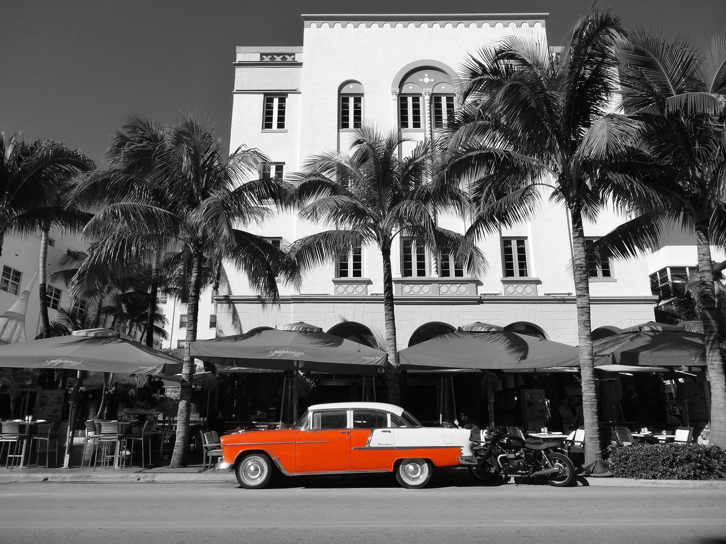 a classic red car parked in front of an art deco building