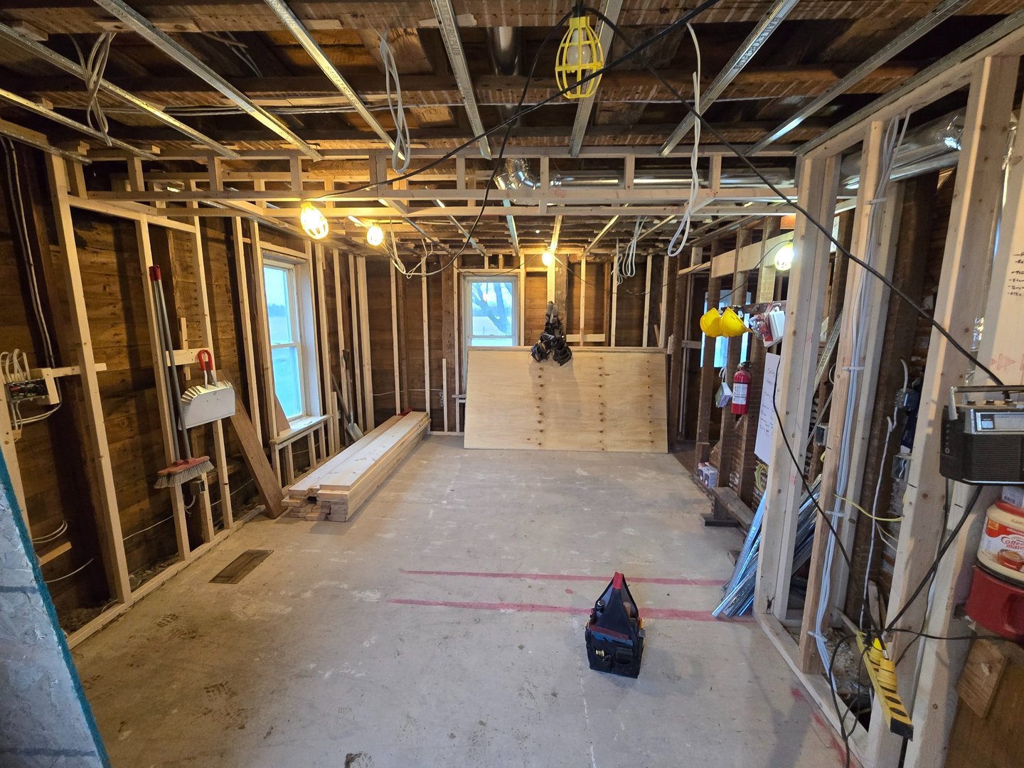 Interior view of a home basement renovation featuring wood stud framing and exposed ceiling joists.