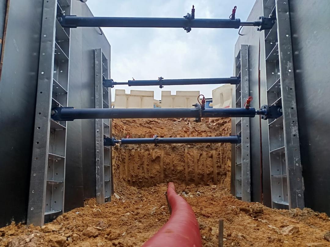 XpressJack quick shoring system supporting a trench during pipe and cable laying installation.