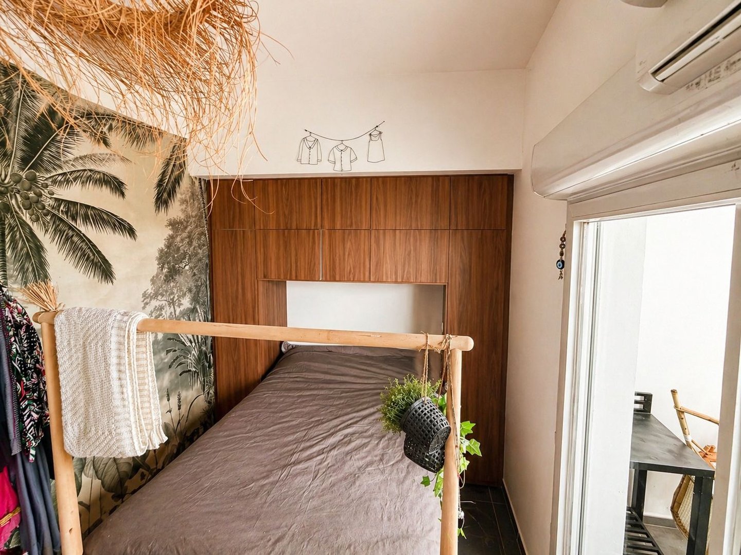 Aménagement chambre à La Ciotat : dressing pont de lit en bois, papier peint jungle et déco bohème.