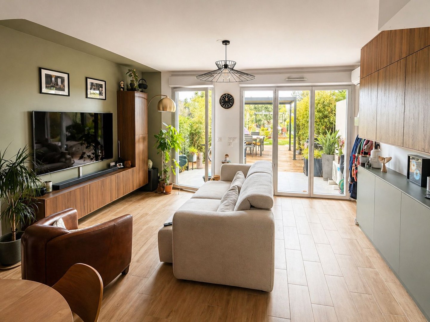 Aménagement séjour lumineux à La Ciotat : canapé clair, buffet moderne, parquet, ouverture extérieur