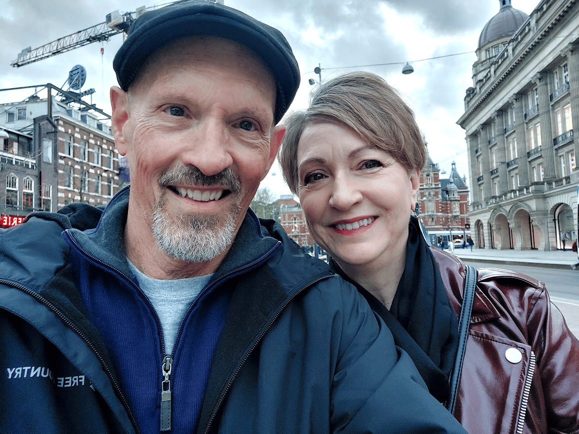 man and woman in front of buildings in amsterdam