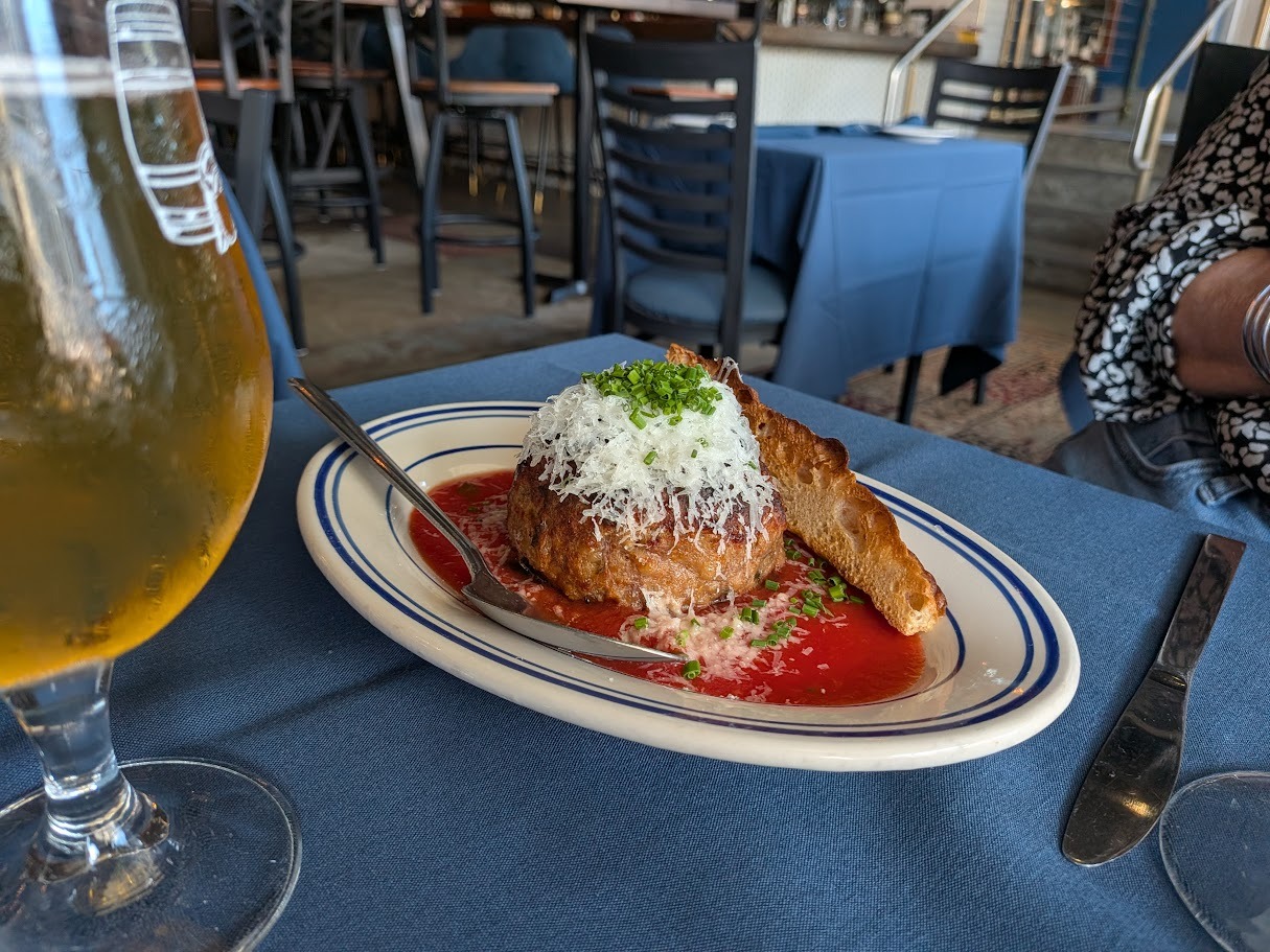 oversized meatball on a plate with sauce