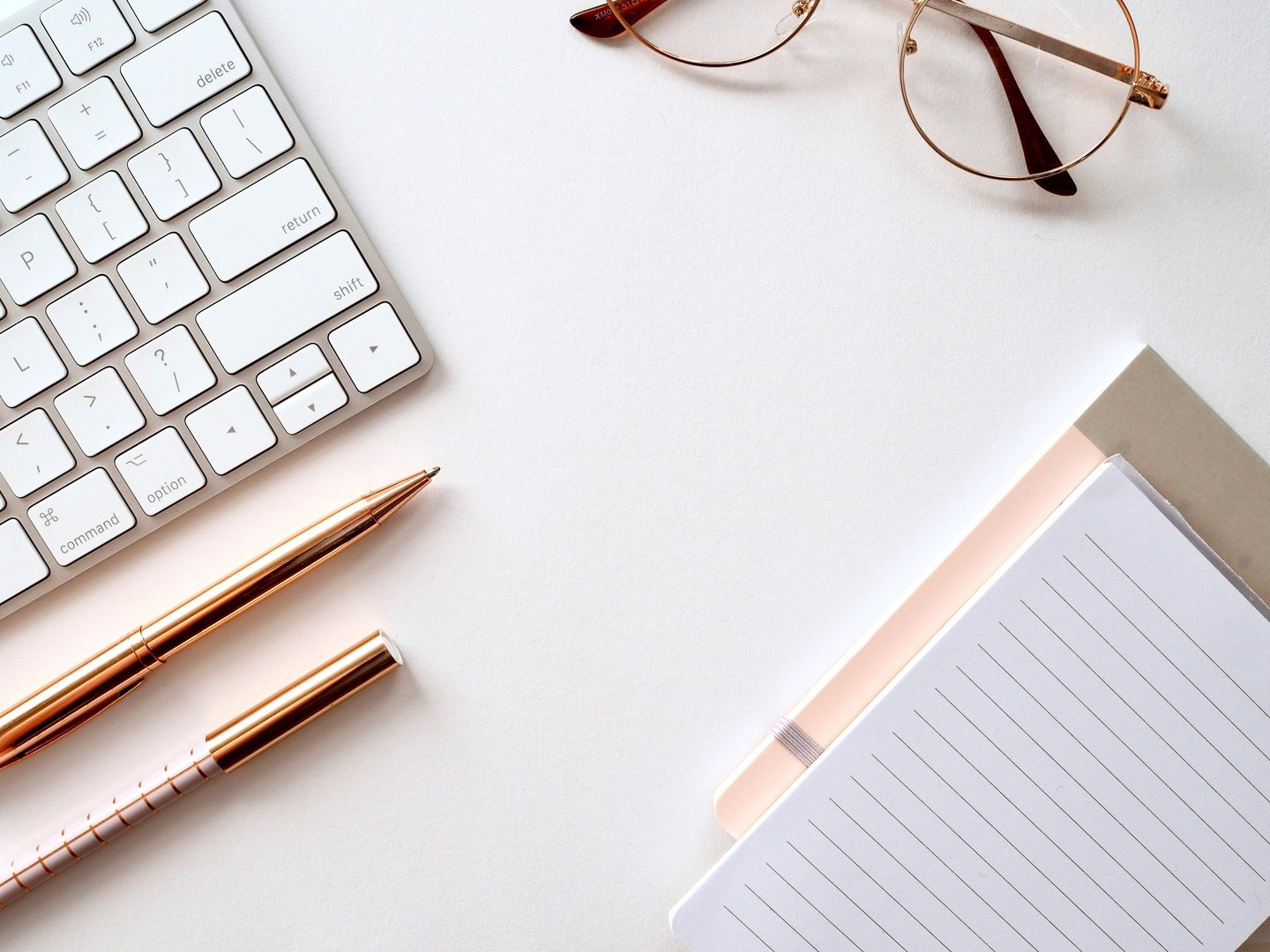 clavier d'ordinateur blanc, crayons roses, carnet de note blanc et des lunettes. tout est en place pour préparer sa retraite