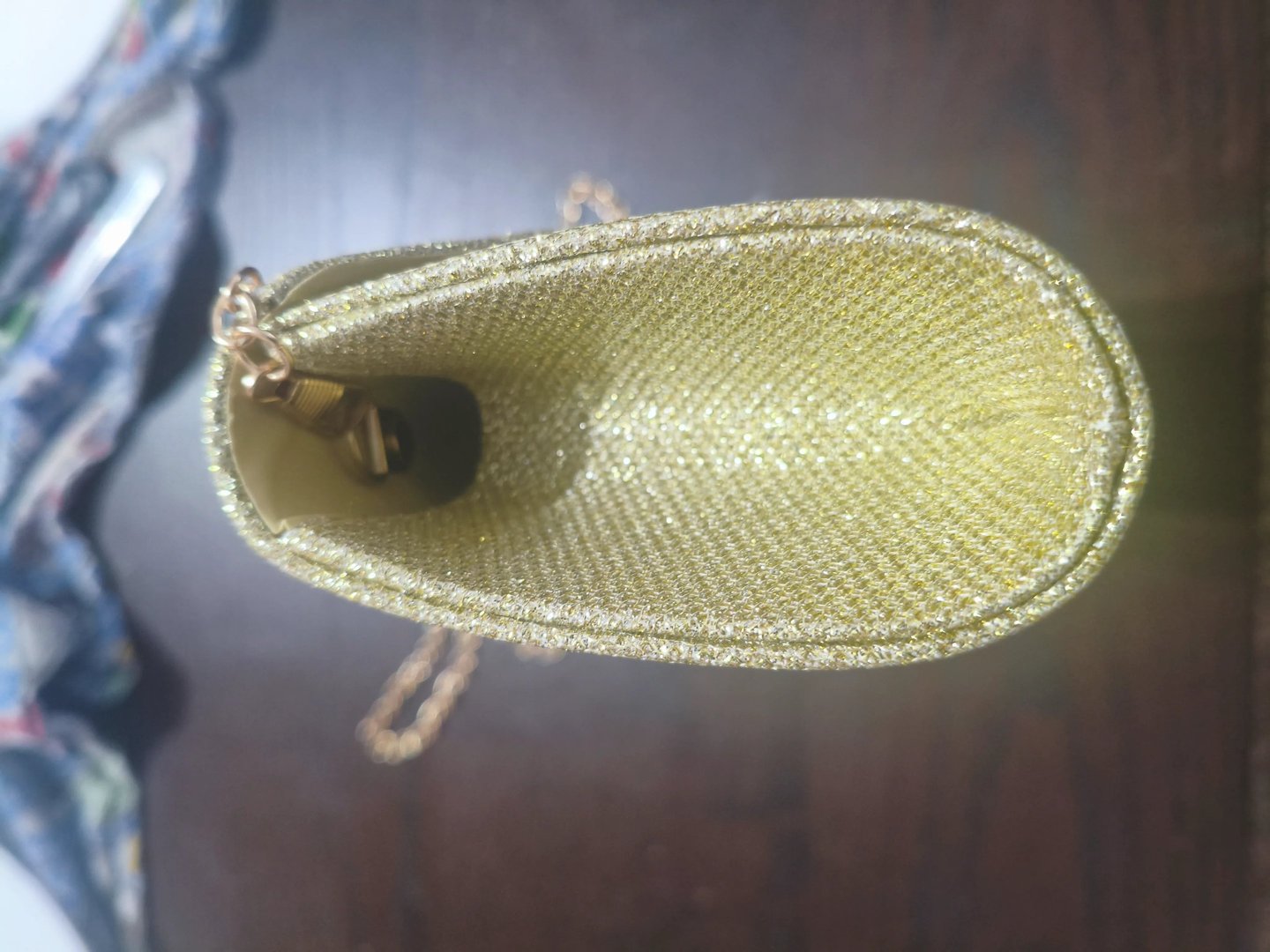 Teste de abertura lateral de mala clutch dourada de festa para avaliar a capacidade e flexibilidade.