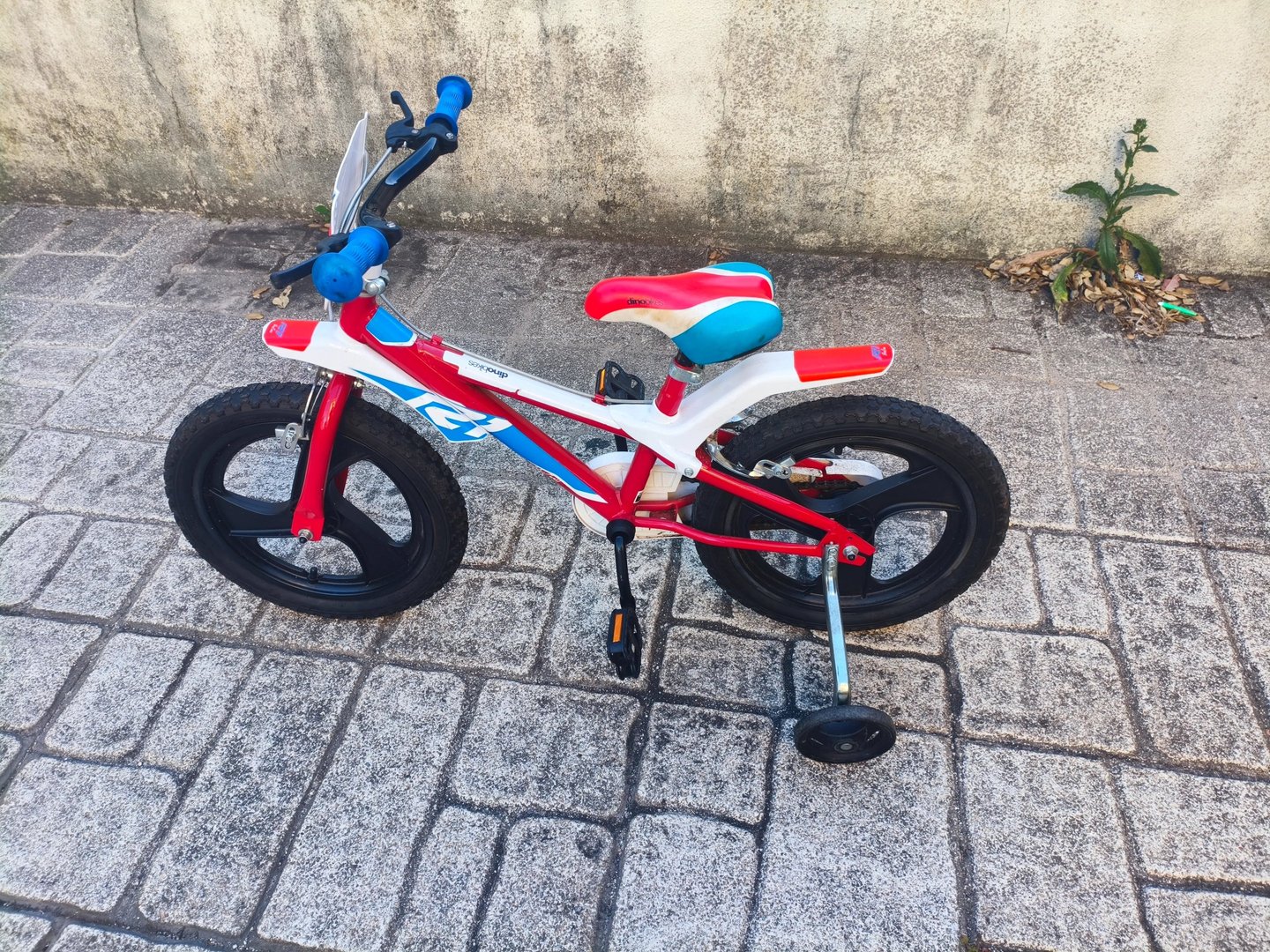 Dino Bikes 14 polegadas vista lateral sem rodas de apoio em calçada