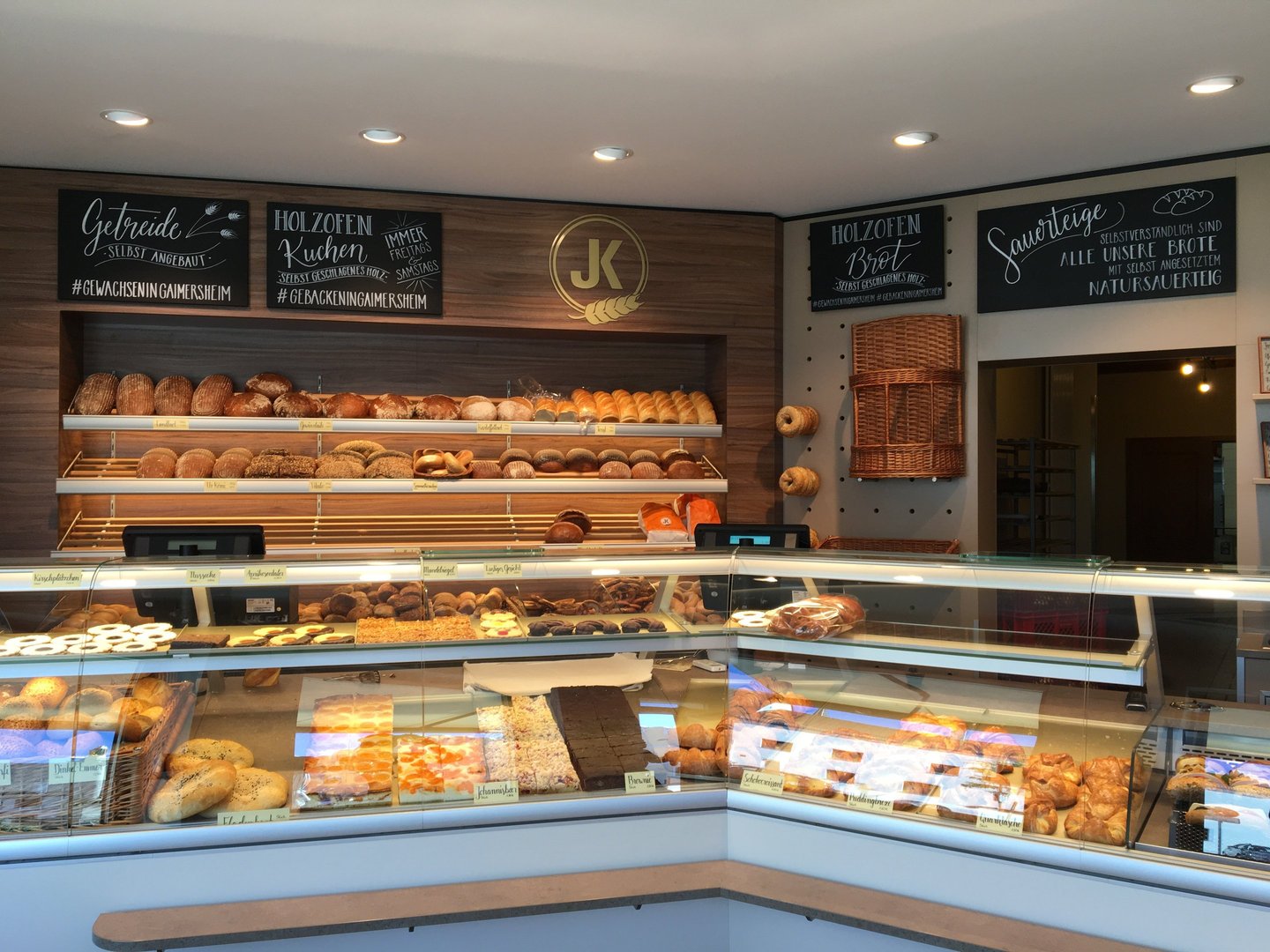 German bakery interior with fresh sourdough bread loaves and artisanal pastries on display shelves.