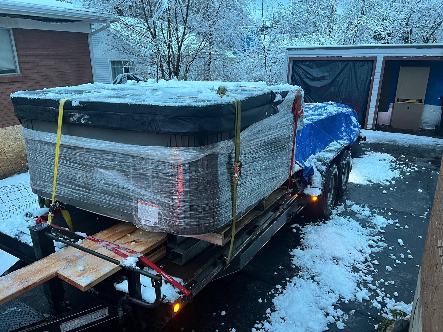 A trailer loaded with a hot tub and lumber for delivery 