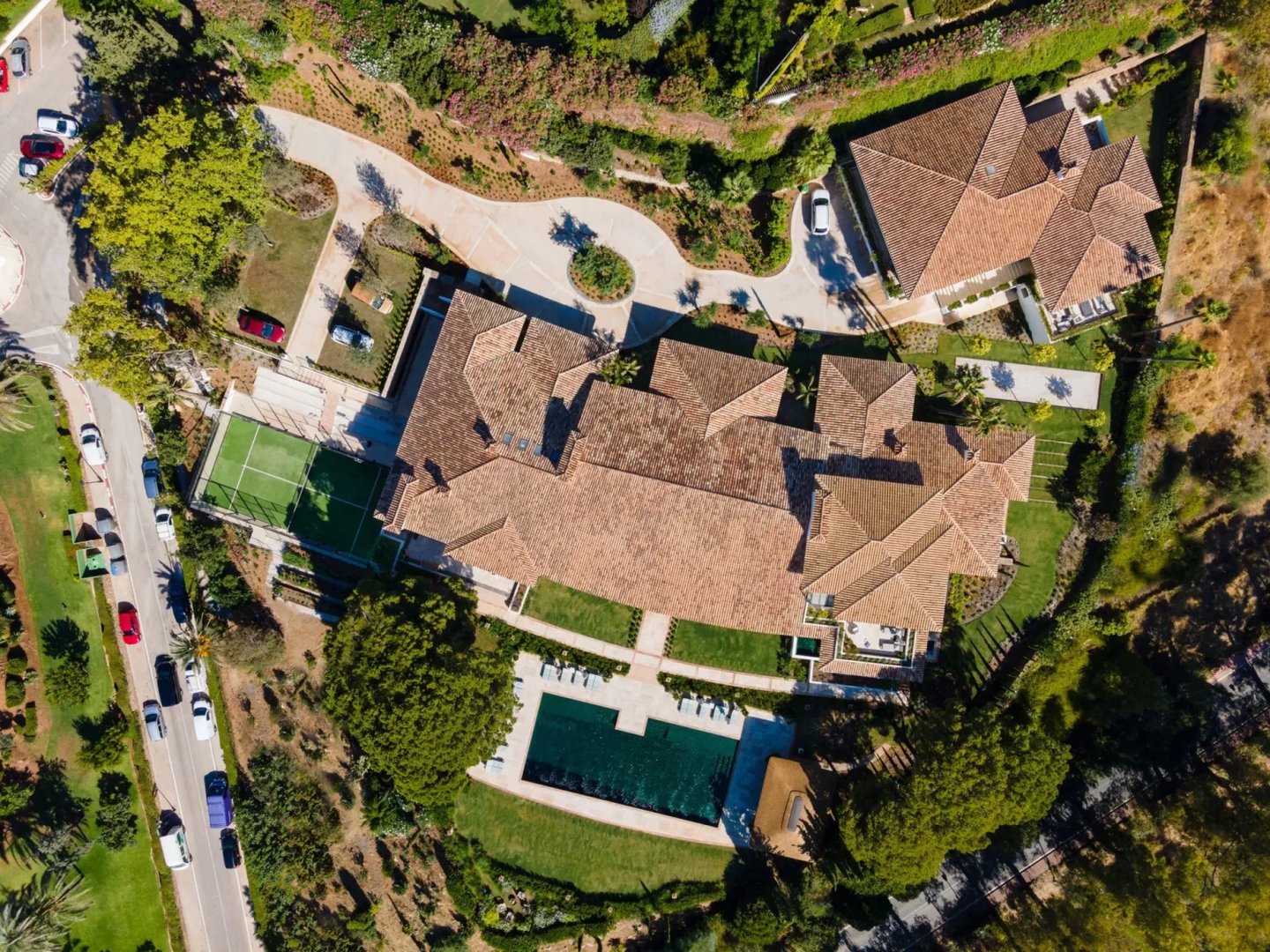 Aerial view of estate with pool, tennis court and landscaped gardens